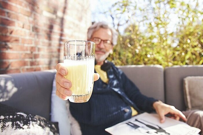 Man holds glass with Almased in the camera becuase research shows positive effects on blood sugar.